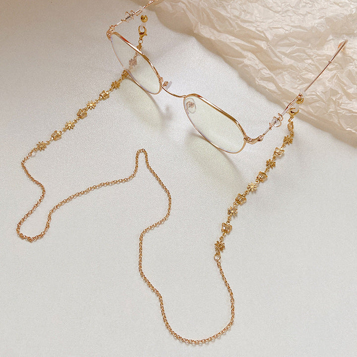 Close-up of elegant women's eyeglass chain, showcasing colorful crystal beads, faux pearls & secure connectors.