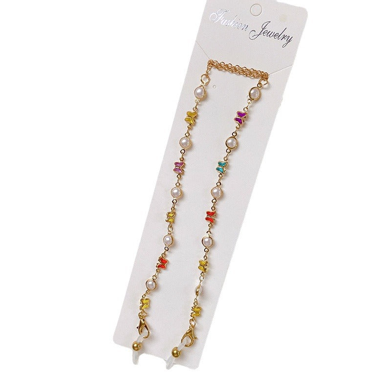 Woman wearing a chic eyeglass chain with colorful crystals & pearls, a functional & fashionable eyewear accessory.