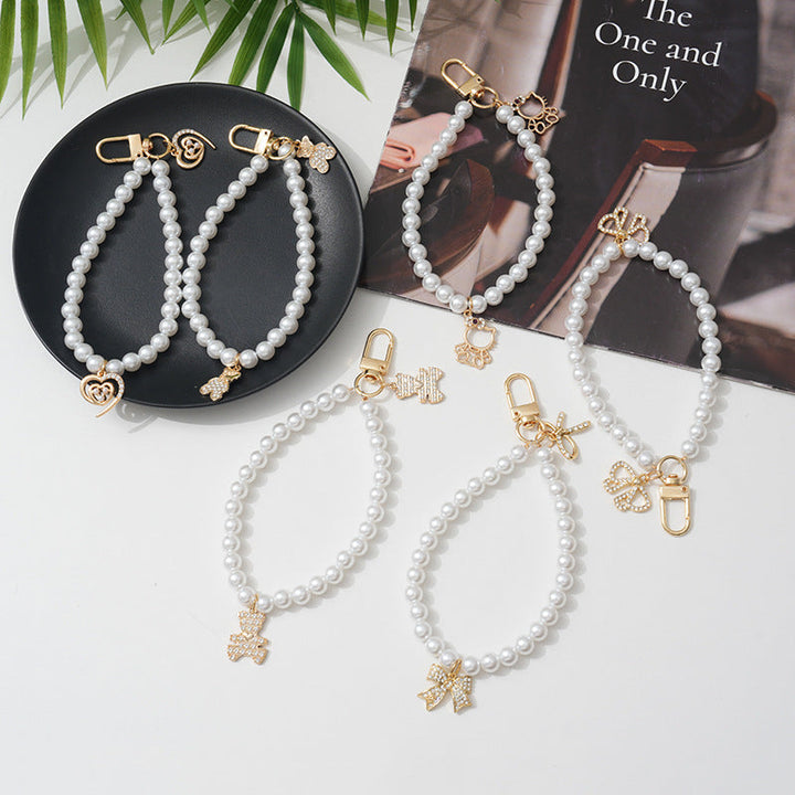 Elegant women's faux pearl bracelet featuring a delicate bow charm, perfect fashion accessory.