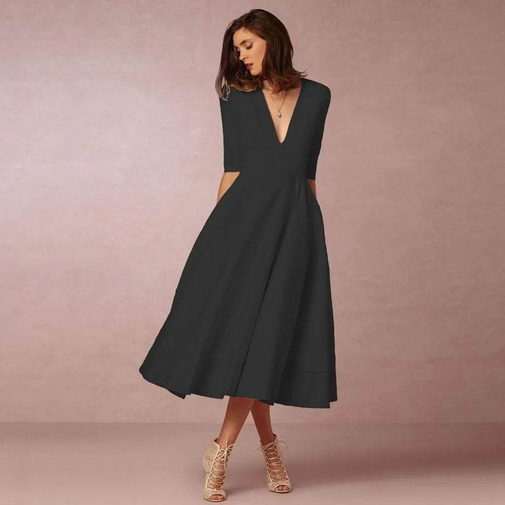 Women's sleek black fitted midi dress, designed for comfort & elegance during summer months. Day to night wear.