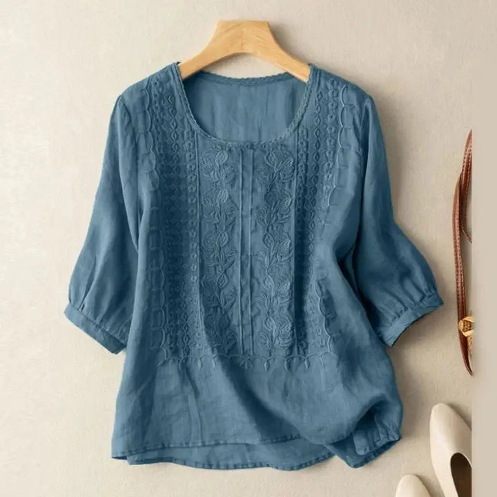 Women's relaxed fit blouse featuring delicate floral embroidery & chic puff sleeves for summer fashion.