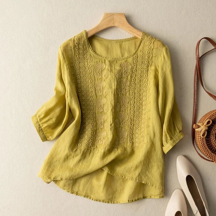 Relaxed women's floral embroidered blouse, featuring puff sleeves & round neck, ideal for casual chic summer style.
