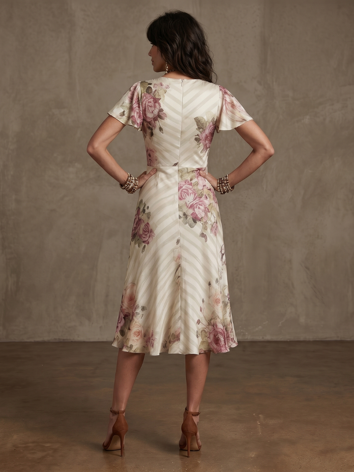 Chic women's floral wrap dress, midi length, with flattering ruched waist and delicate flutter sleeves.