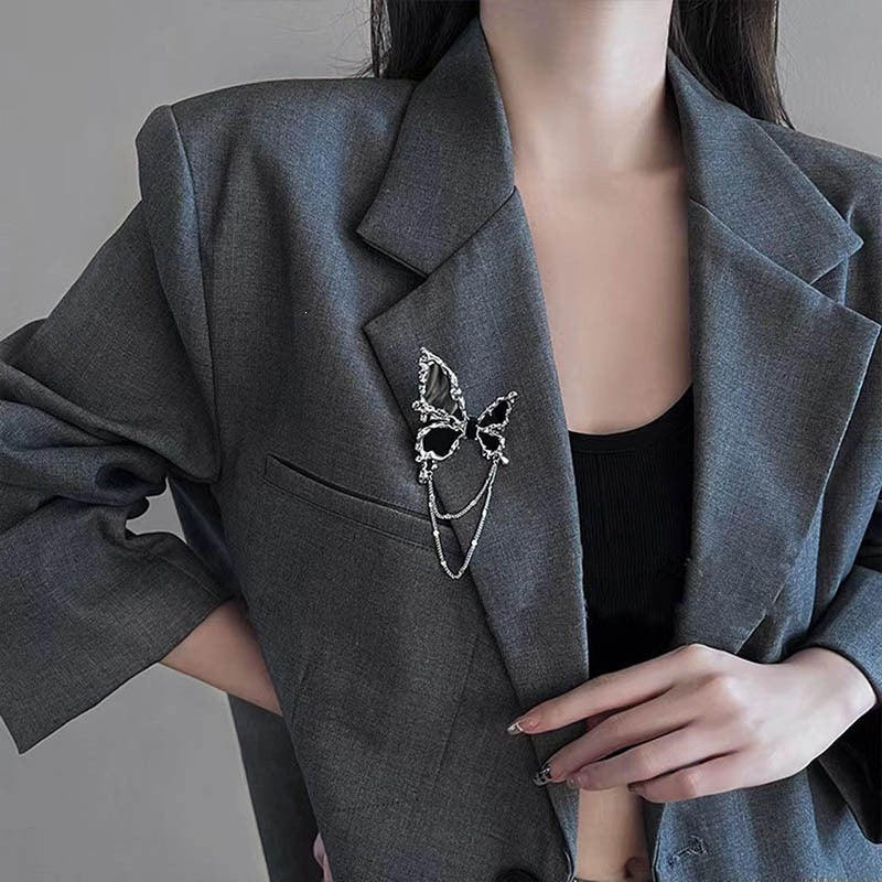Elegant women's flower brooch pin with delicate chain detailing, perfect lapel accessory for any outfit.