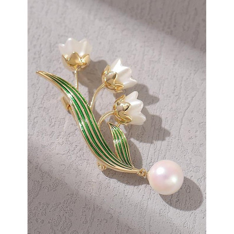 Stylish women's elegant flower brooch with pearl pendant, ideal for wedding attire or a sophisticated accessory.