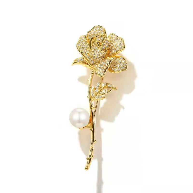 Exquisite women's elegant flower brooch with brilliant rhinestones and a central pearl. A fashionable jewelry pin.