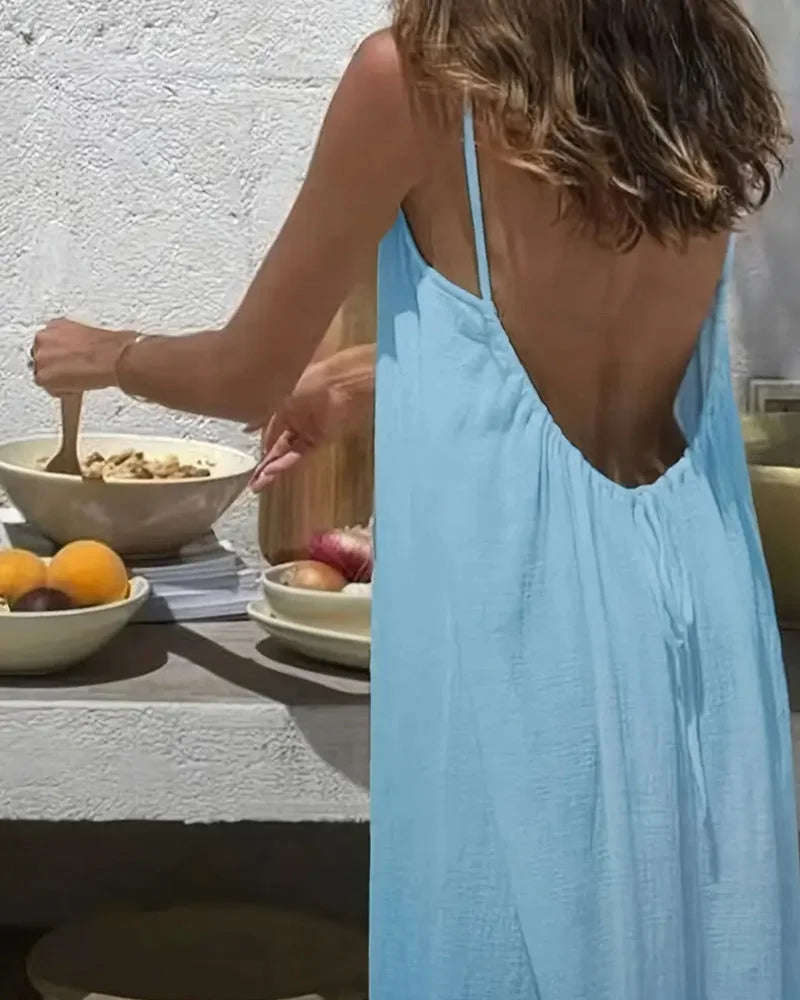 Woman enjoying summer in a flowing cami maxi dress, sleeveless, elegant and comfortable beachwear.