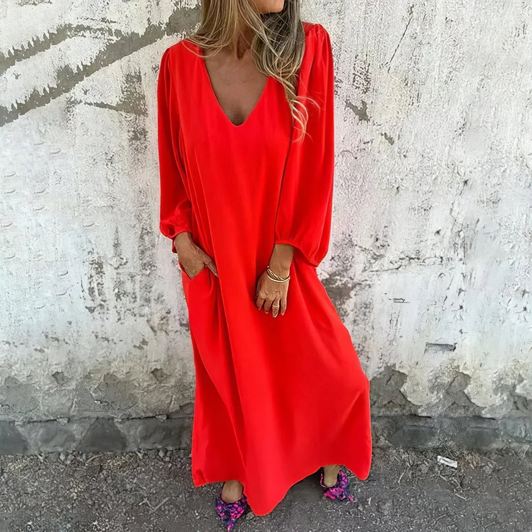 Long women's dress: V-neck, elegant bishop sleeves, and convenient pockets. Ideal flowing maxi style.