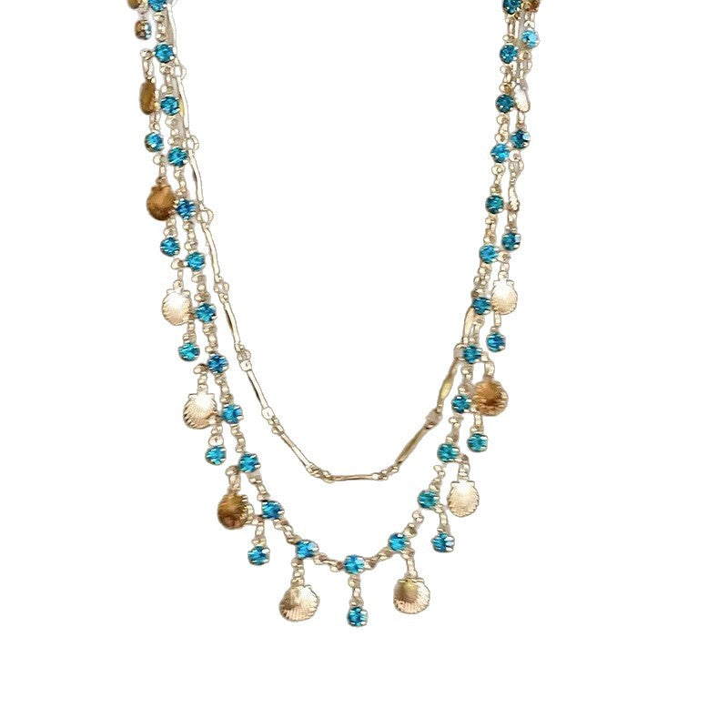 Close-up of the delicate shell color gemstone pendant on an elegant women's adjustable necklace.