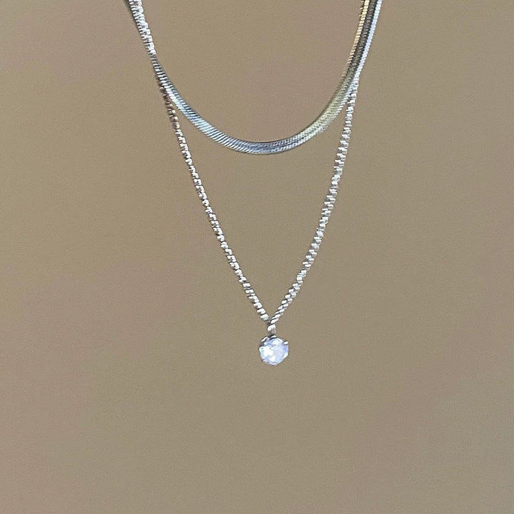 Woman wearing an adjustable silver layered choker necklace, showcasing its elegant style and versatility.