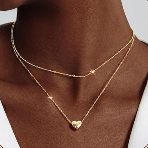 Elegant women's gold layered necklace with a chic heart pendant, perfect fashion jewelry for a gift.