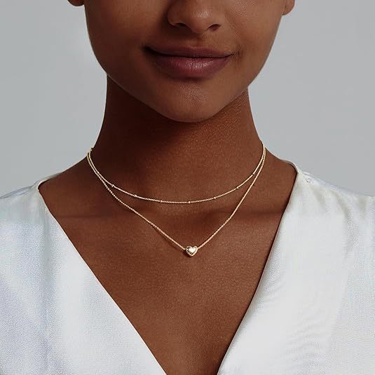 Chic gold-toned layered necklace for women, featuring a delicate heart pendant, elegant and fashionable.
