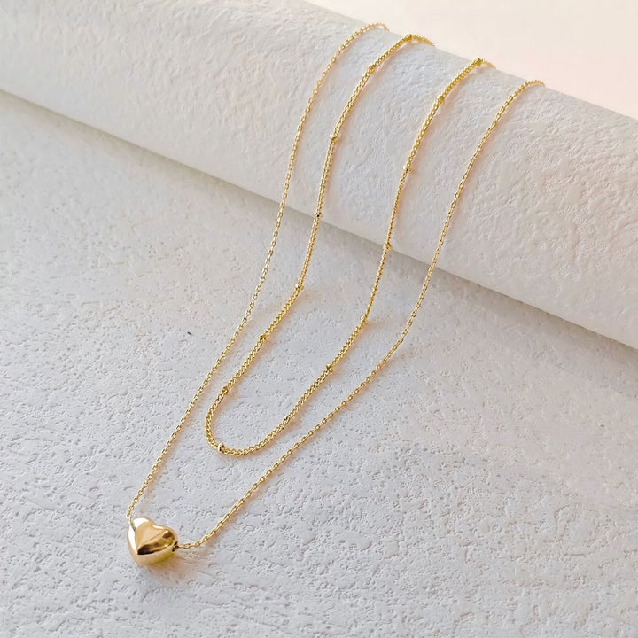 Women's elegant gold heart pendant layered necklace, a perfect chic jewelry gift for her, enhances any outfit.