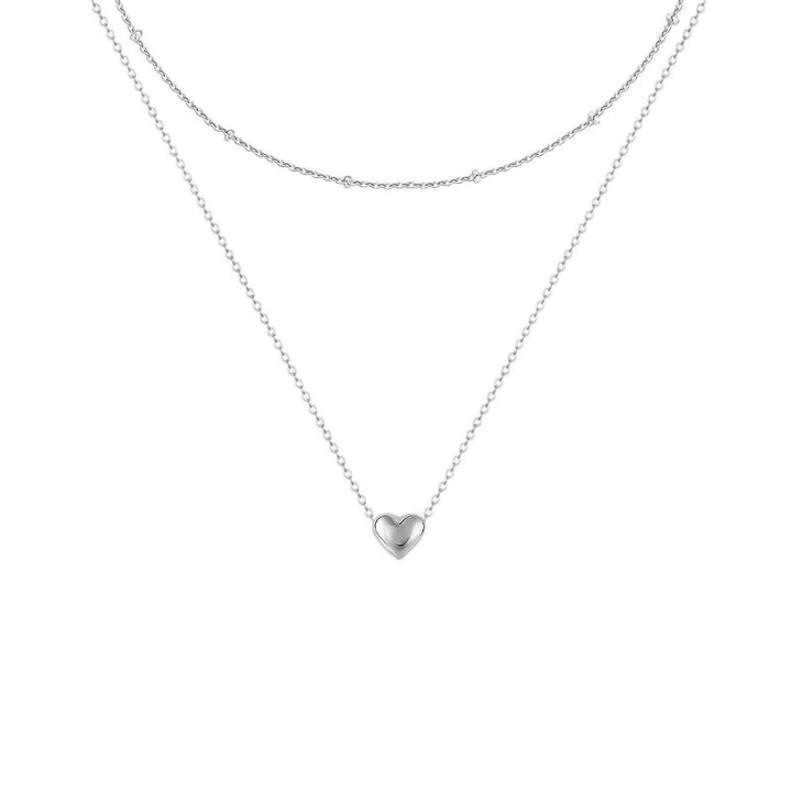Shining gold layered necklace with a central heart pendant, elegant women's jewelry that's chic and stylish.