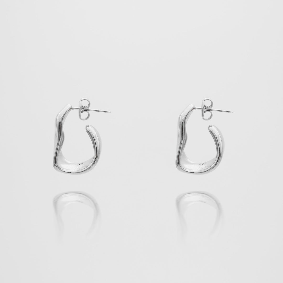 Close-up of a women's gold textured half hoop earring, showcasing its unique finish.