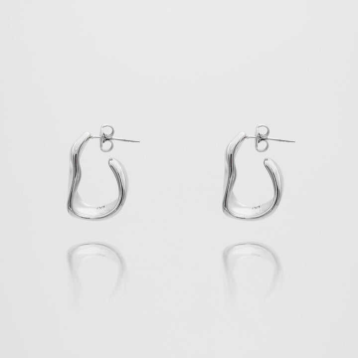 Close-up of a women's gold textured half hoop earring, showcasing its unique finish.