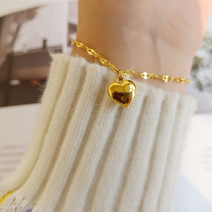 Adjustable women's gold tone bracelet with a delicate heart charm, ideal for elegant everyday style.