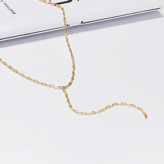 Close-up of a delicate gold Y-chain lariat necklace, elegant women's fashion jewelry.