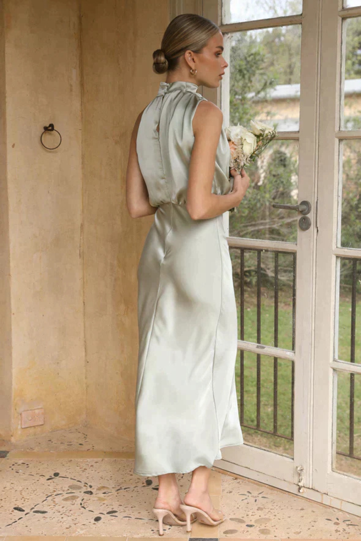 Sleeveless elegant midi dress with a halter neck, perfect for wedding guest attire & formal dinners.