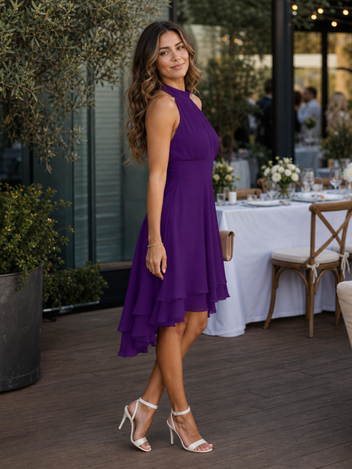 Sleeveless purple halter neck dress, knee length, featuring a unique layered hem. Versatile for day or evening.