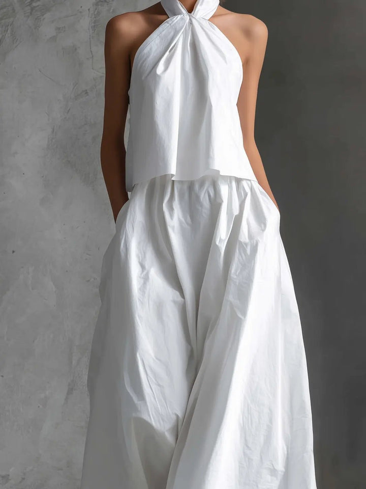 Fashionable women's sleeveless halter neck top & elegant maxi skirt matching set for summer style.