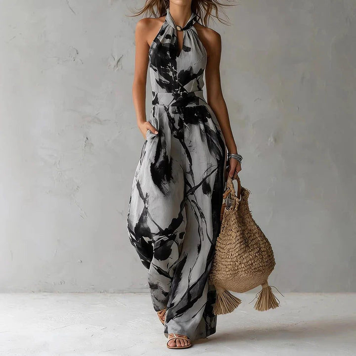Elegant women's halterneck wide leg jumpsuit for summer resort wear. Flowing, chic party outfit.