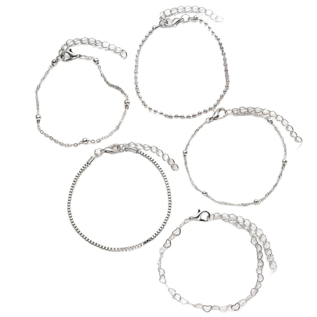 Delicate women's heart charm bracelet set, elegant gold & white fashion accessory.