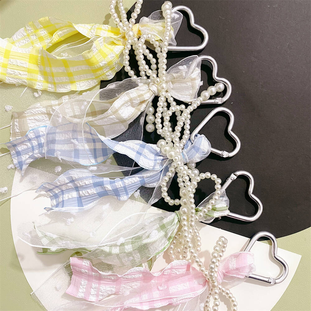 Versatile women's heart keychain, elegant pearl & ribbon charm, stylish accessory for bags, purses & keys.