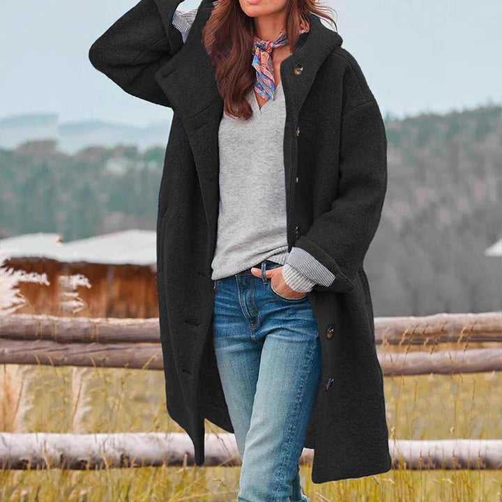 Woman wearing a chic hooded long winter coat for casual cold weather outerwear, standing elegantly.