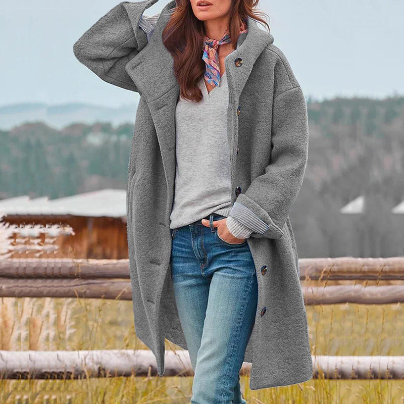 Back view of a fashionable women's hooded winter coat, highlighting its long, warm outerwear design.