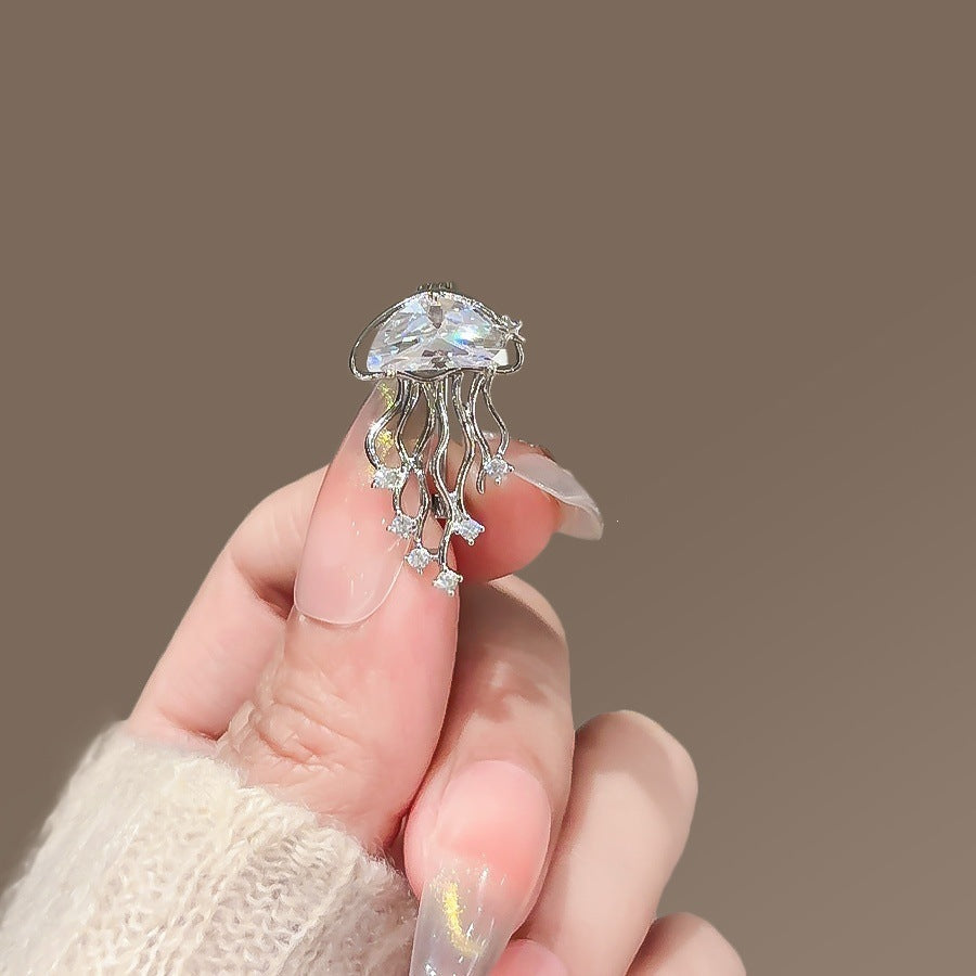 Elegant women's jellyfish brooch with sparkling blue crystals, perfect fashion accessory.