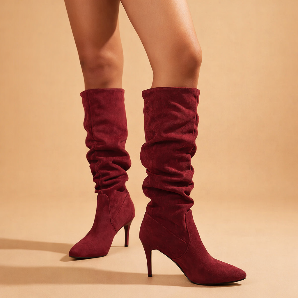 Elegant women's knee-high slouch boots with stiletto heel and pointed toe, perfect for winter fashion.