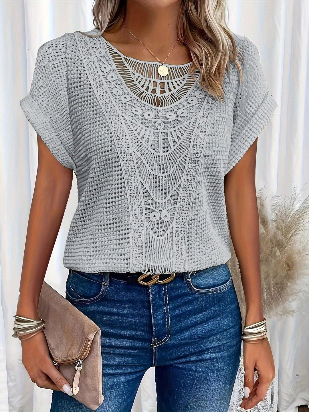 Close-up of intricate details on elegant women's knitted top, showcasing sophisticated texture & design.