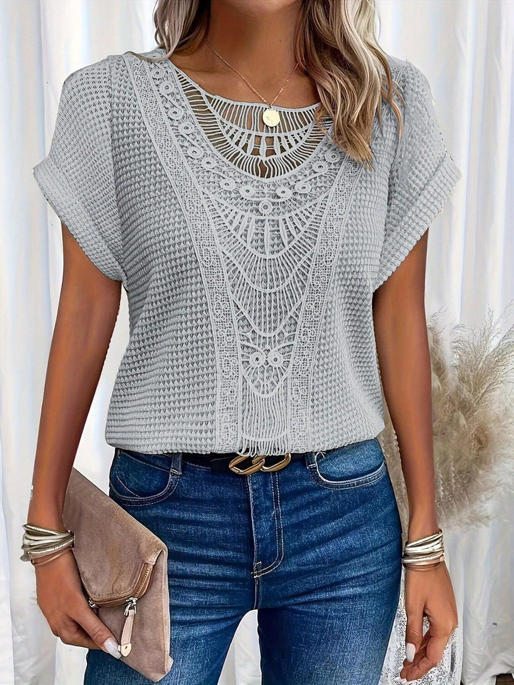 Close-up of intricate details on elegant women's knitted top, showcasing sophisticated texture & design.