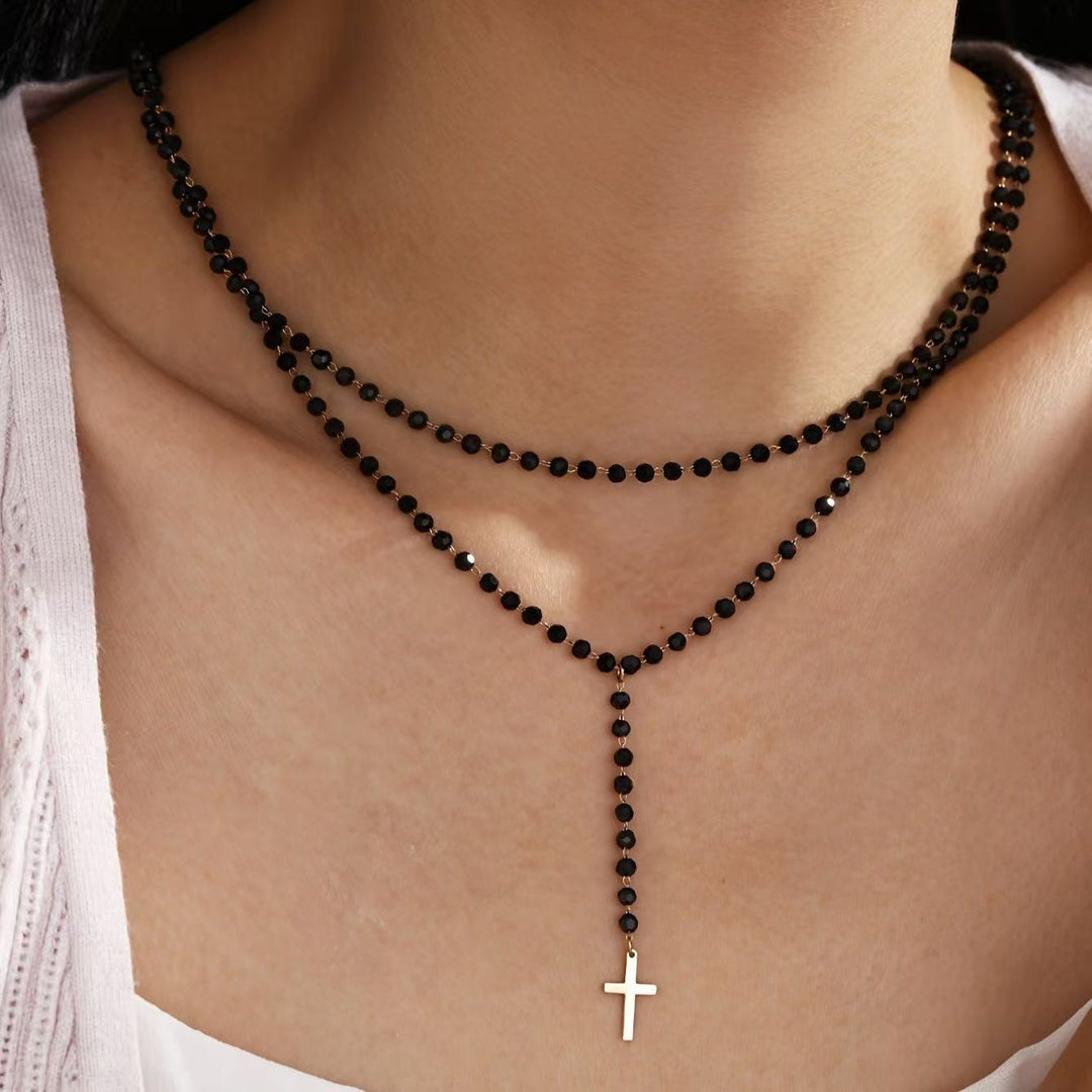 Elegant women's layered beaded necklace featuring a delicate cross and star pendant. Perfect spiritual accessory.