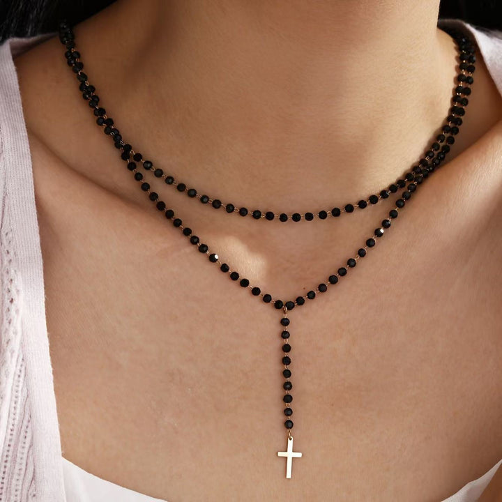 Elegant women's layered beaded necklace featuring a delicate cross and star pendant. Perfect spiritual accessory.
