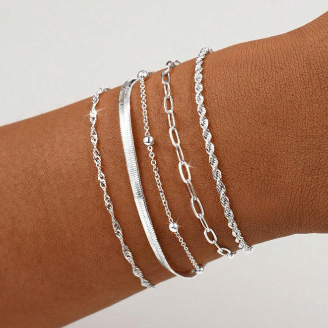 Close-up of a gold tone layered chain bracelet set for women, delicate and elegant accessory.