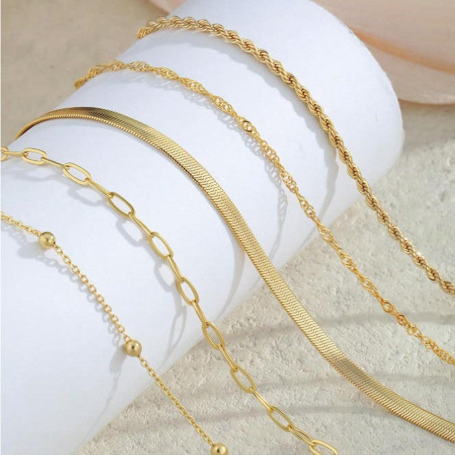 Women's wrist wearing an elegant layered chain bracelet set, perfect fashion accessory & gift.