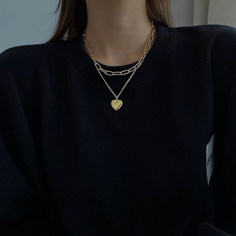 Close-up of a delicate white layered necklace with small heart pendants on multiple thin chains.