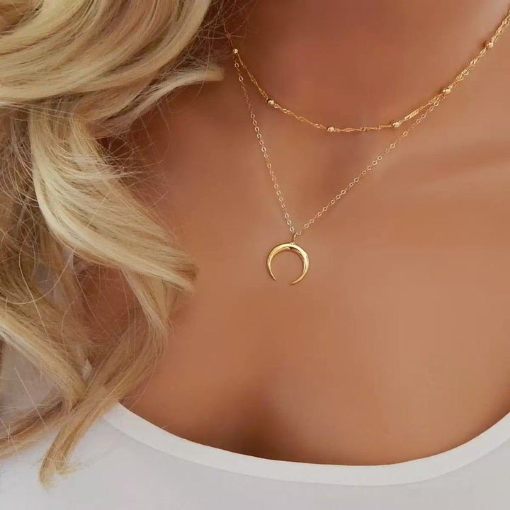 Elegant women's layered gold necklace featuring a delicate crescent moon pendant. Perfect celestial fashion jewelry.