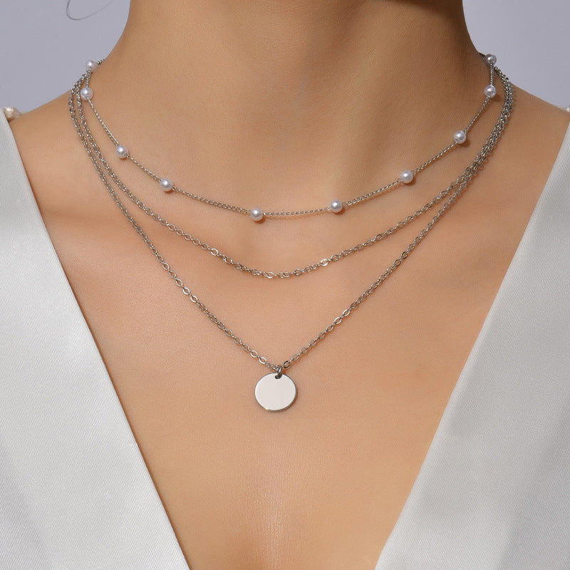 Stunning multi-layered necklace with lustrous white pearls and golden chains for women.
