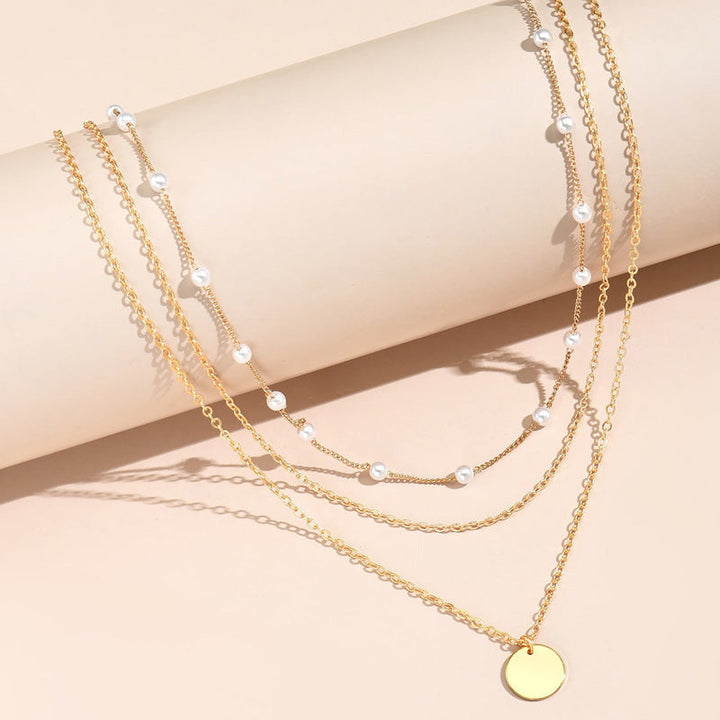 Fashion-forward women's layered necklace blending white pearls with delicate gold chains.
