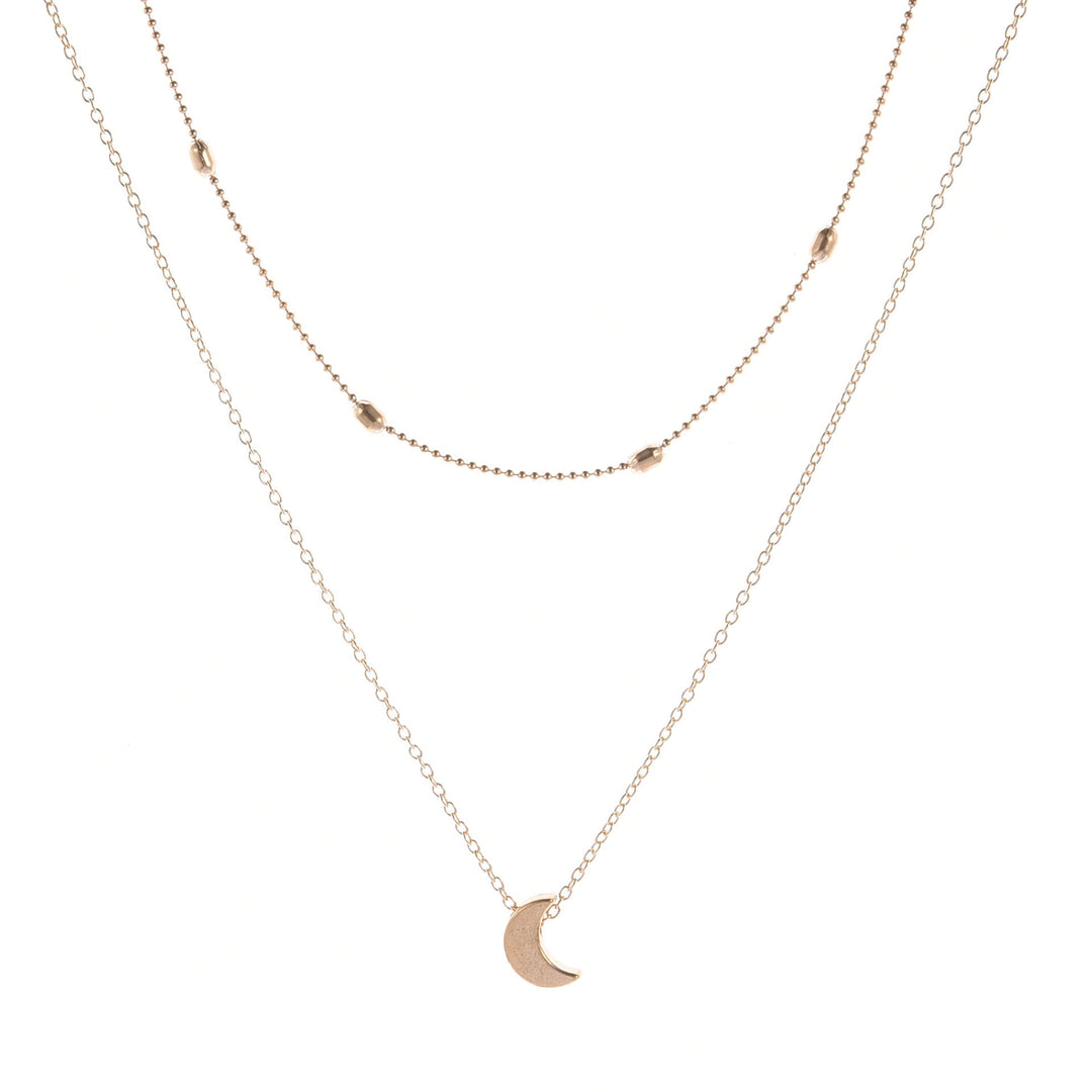 Close-up of a delicate gold layered necklace showing a small heart charm, perfect for women's jewelry.