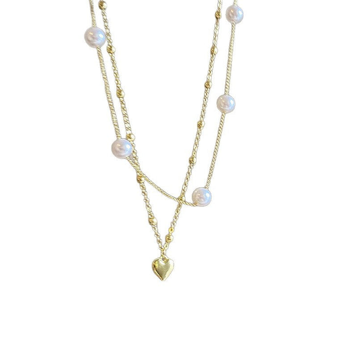 Stunning women's layered necklace with a charming heart pendant and classic pearl-color finish. Adjustable jewelry.