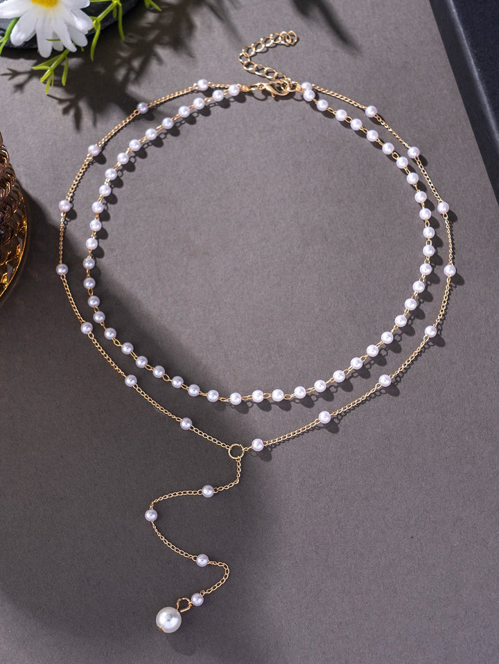 Chic layered pearl necklace for women, showcasing delicate white pearls & shiny gold chains.