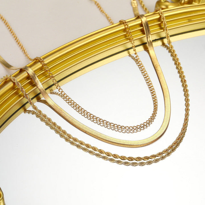 Close-up of a gold layered chain necklace, showcasing intricate textured links, a women's accessory.