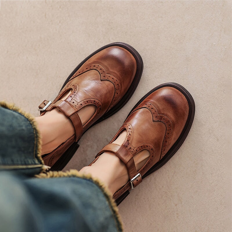 Elegant women's leather Mary Janes with T-strap, round toe, and brogue details for vintage comfort.
