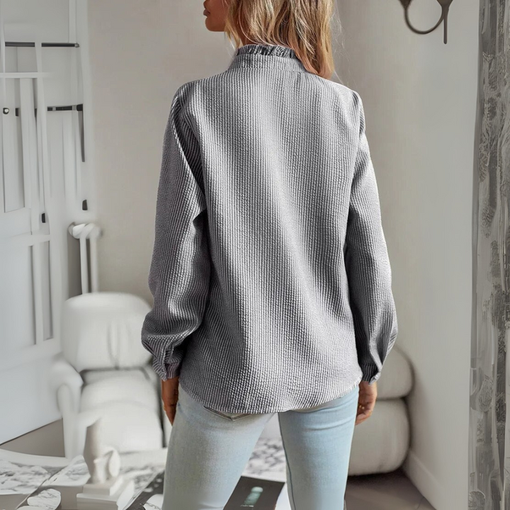 Women's elegant long-sleeve blouse. Sophisticated tie-neck top with puff sleeves for stylish workwear.