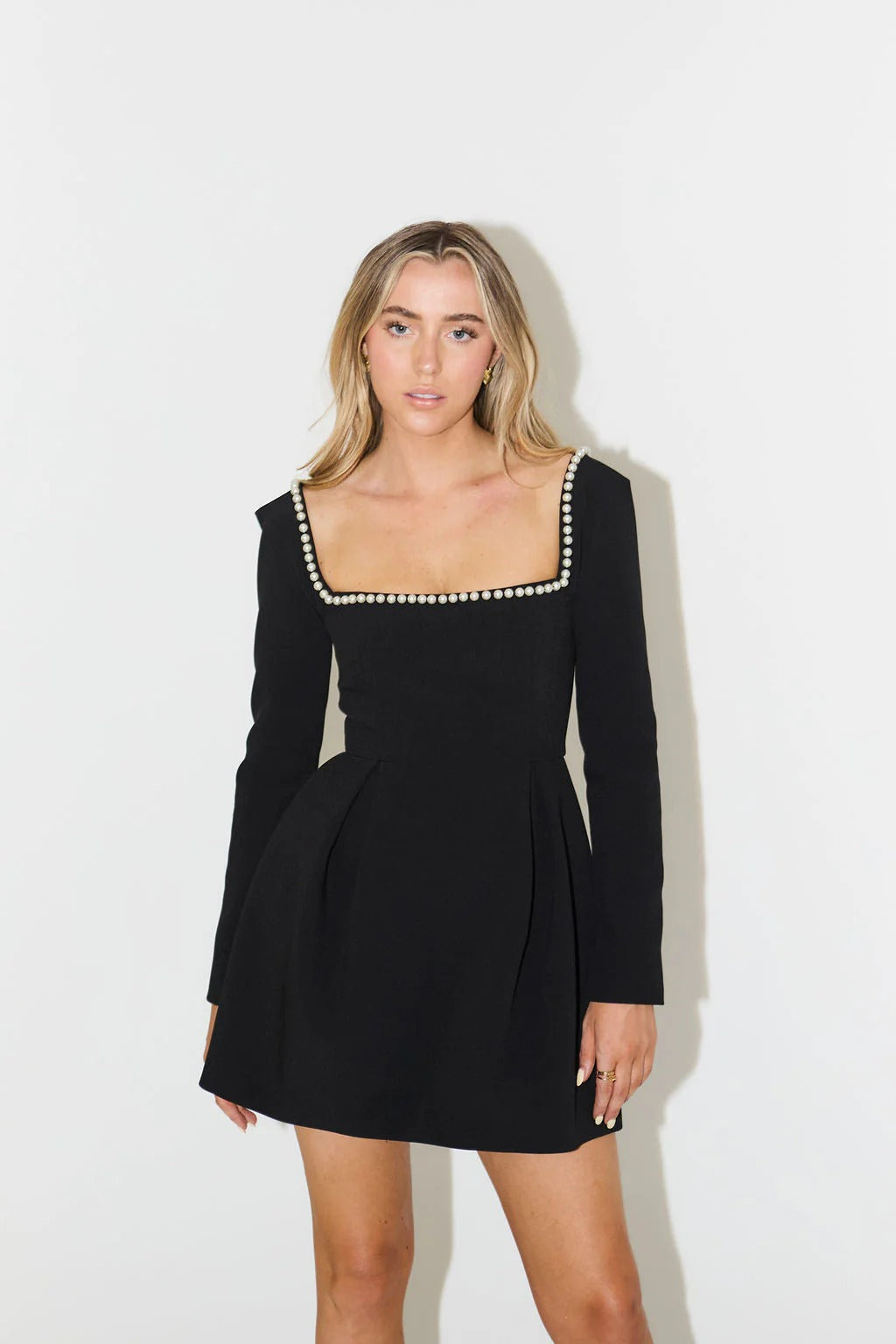 Elegant women's long sleeve mini dress with pearl trim, perfect for cocktail parties & special occasions.