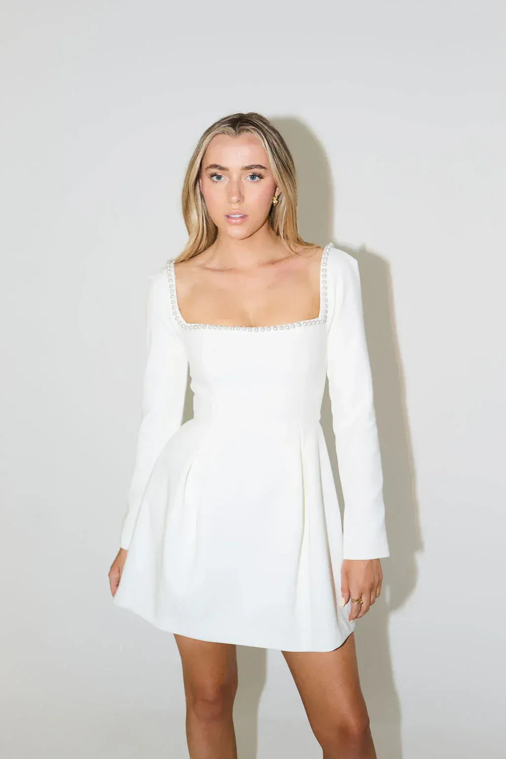 Sophisticated women's long sleeve mini dress with elegant pearl trim, ideal for cocktail & evening wear.